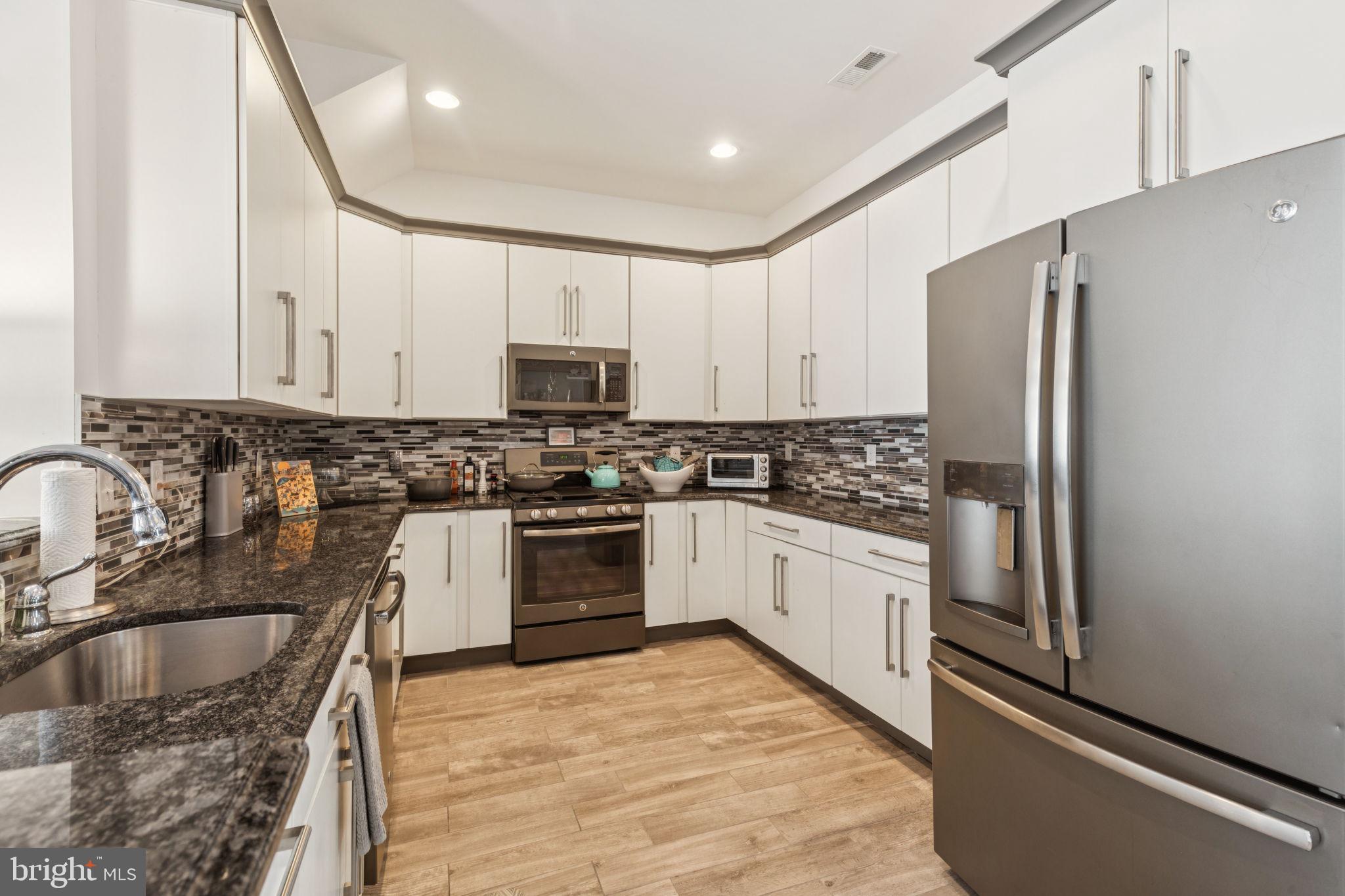 2303 Roma Drive Philadelphia, PA 19145 - Photo 23 of 80 a kitchen with granite countertop a refrigerator sink and microwave