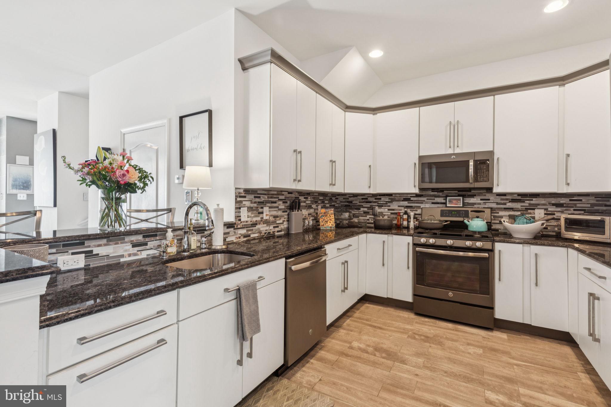 2303 Roma Drive Philadelphia, PA 19145 - Photo 24 of 80 a kitchen with granite countertop white cabinets and stainless steel appliances