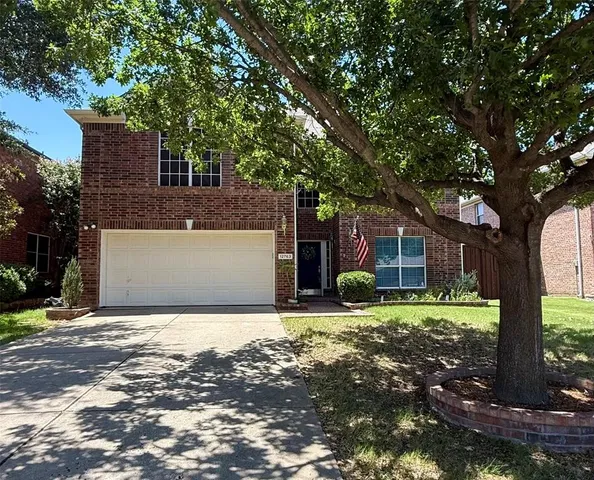 a front view of a house with a yard and trees