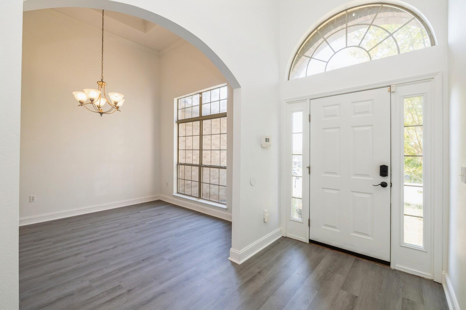410 Wych Circle Crestview, FL 32536 - Photo 2 of 34 an empty room with wooden floor chandelier and windows