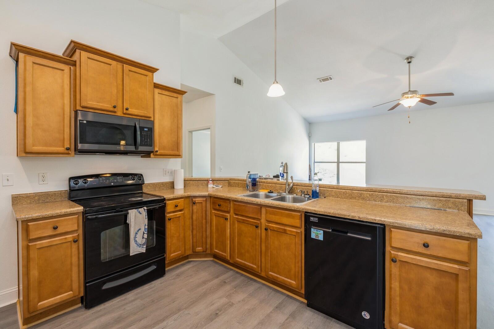 410 Wych Circle Crestview, FL 32536 - Photo 30 of 34 a kitchen with stainless steel appliances wooden cabinets and a stove top oven