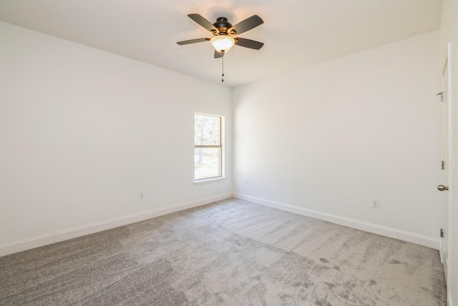410 Wych Circle Crestview, FL 32536 - Photo 7 of 34 an empty room with a window and a fan
