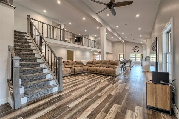 a living room with couches and kitchen view with wooden floor