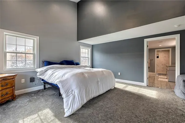 a spacious bedroom with a bed and a window