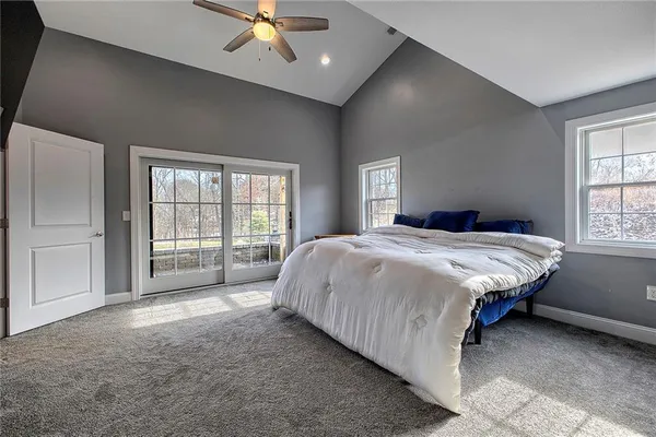 a spacious bedroom with a large bed and a chandelier