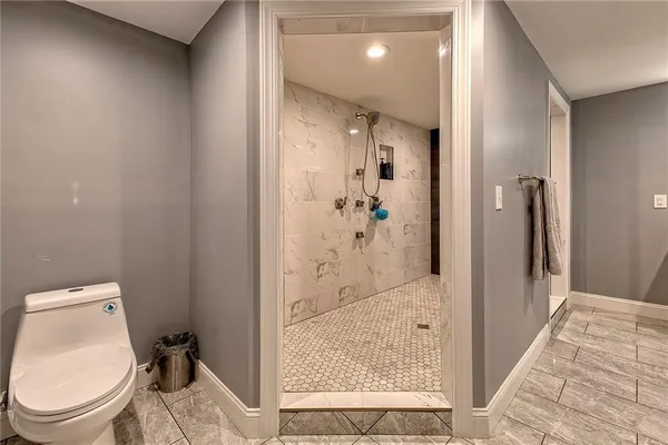 a bathroom with a granite countertop toilet a sink and a mirror