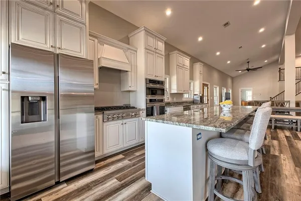 a kitchen with stainless steel appliances kitchen island granite countertop a sink and cabinets