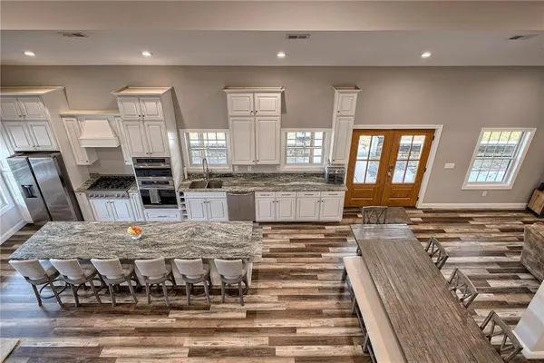 a large kitchen with stainless steel appliances granite countertop a stove and a sink