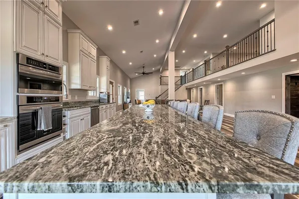 a kitchen with stainless steel appliances granite countertop a refrigerator a stove and a sink