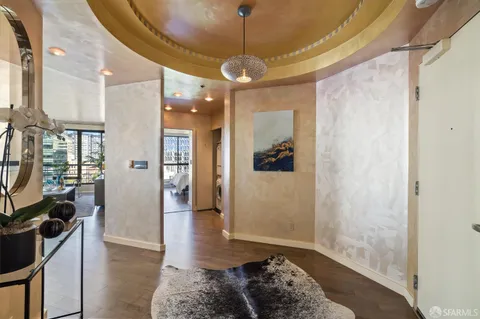 a view of a hallway with wooden floor and a livingroom