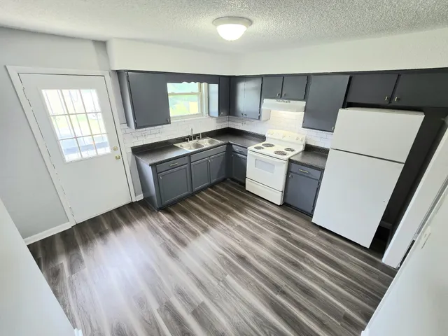a kitchen with a refrigerator and a stove top oven