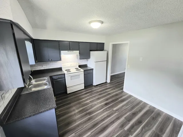 a view of kitchen with wooden floor and electronic appliances