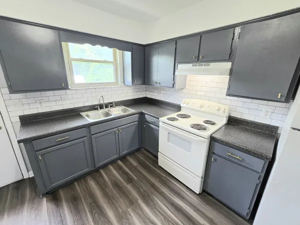 a kitchen with a sink stove and cabinets