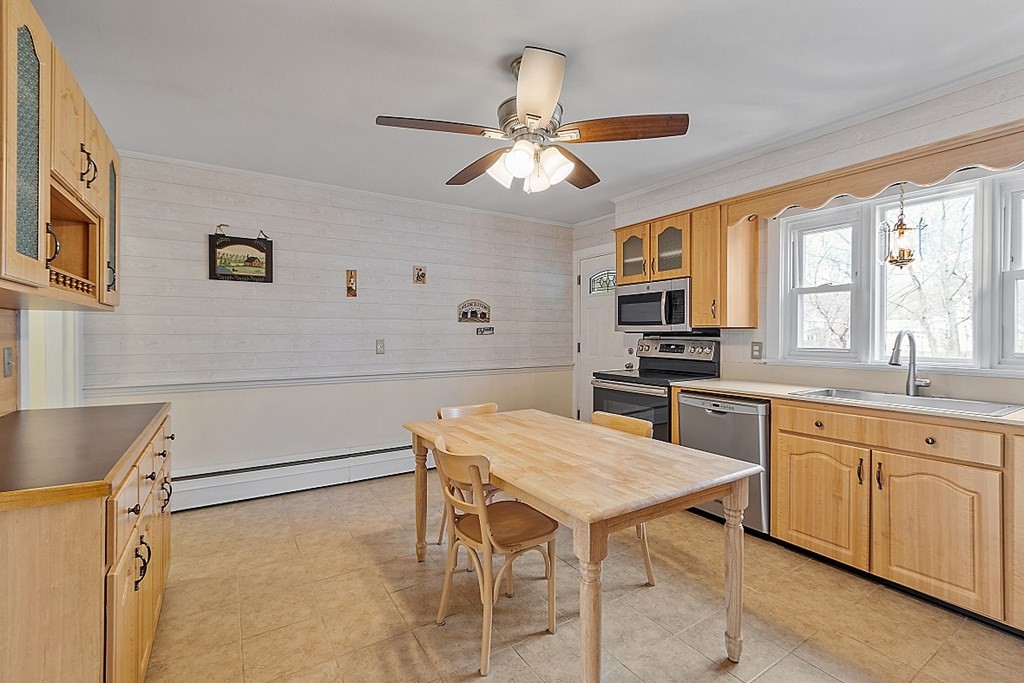 19 South Hampton Road Amesbury, MA 01913 - Photo 14 of 42 a kitchen with a table chairs microwave and cabinets