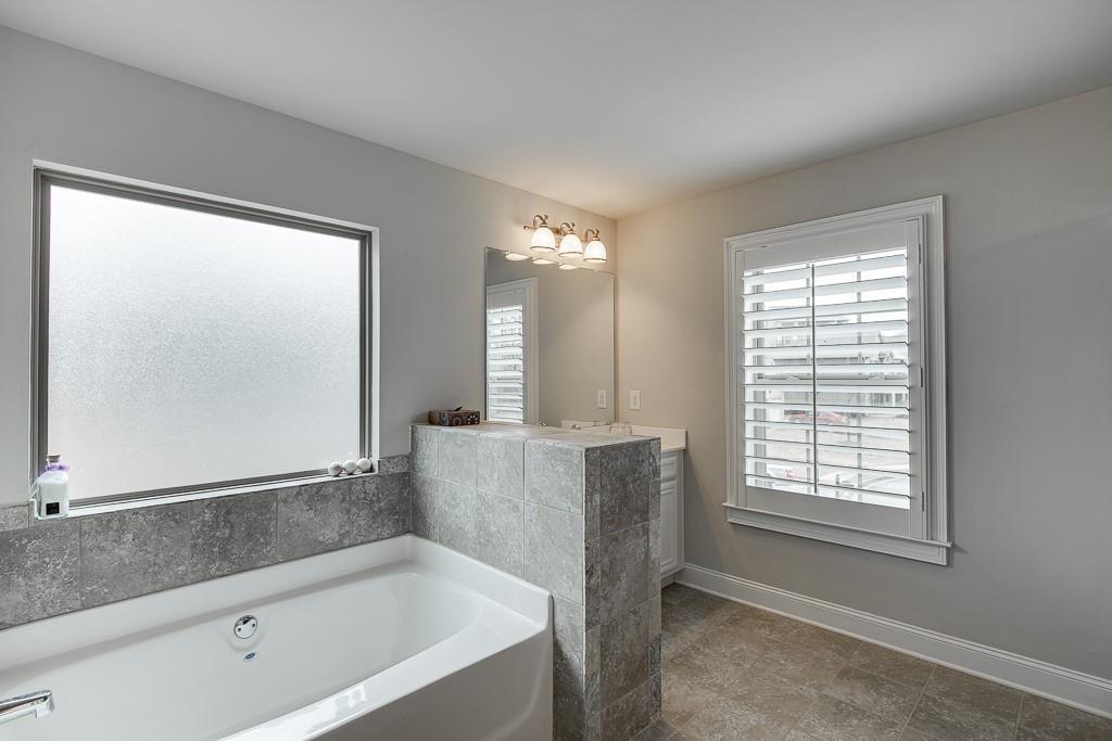 914 Rainsong Court Braselton, GA 30517 - Photo 20 of 37 a bathroom with a bathtub and a shower