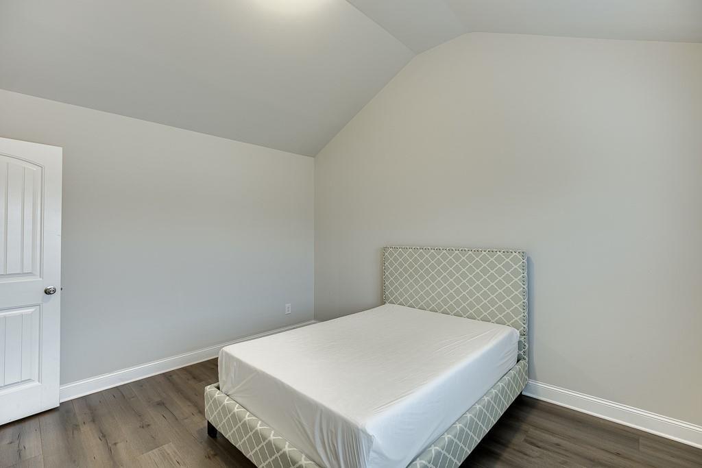 914 Rainsong Court Braselton, GA 30517 - Photo 25 of 37 a bedroom with a bed and wooden floor