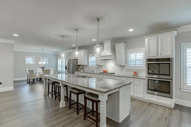 a kitchen with kitchen island a dining table chairs and wooden floor