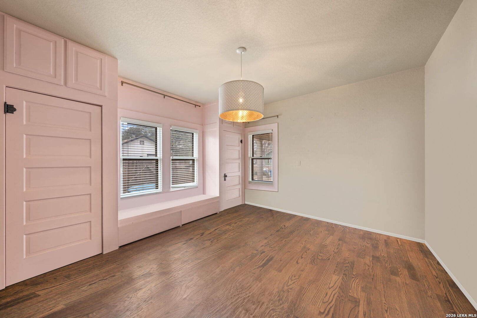 312 Lytle Street Kerrville, TX 78028 - Photo 10 of 17 an empty room with wooden floor cabinet and windows