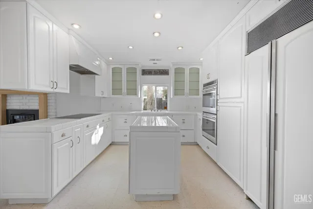a kitchen with granite countertop a sink and white cabinets