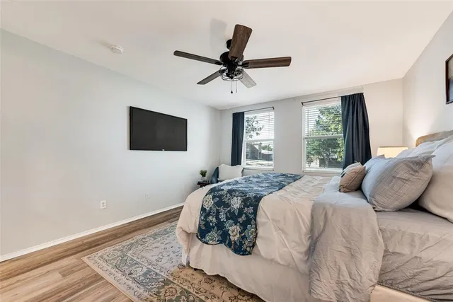 a bedroom with a bed a window and a flat screen tv