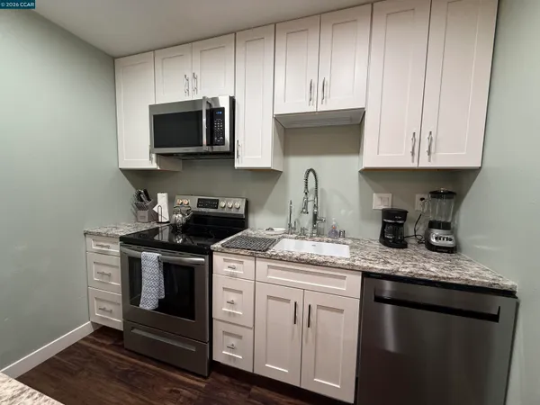a kitchen with stainless steel appliances granite countertop a sink stove and microwave