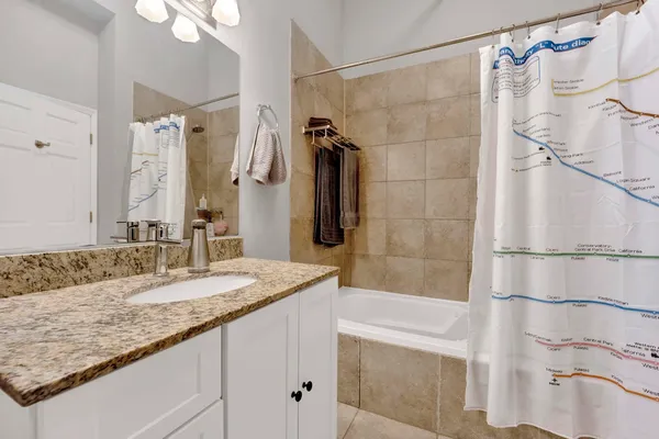 a bathroom with a granite countertop sink mirror and shower