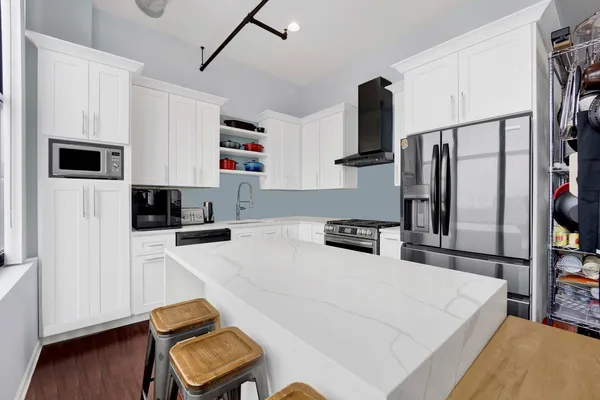 a kitchen with stainless steel appliances a refrigerator sink and microwave