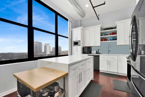 a kitchen with stainless steel appliances sink cabinets and wooden floor
