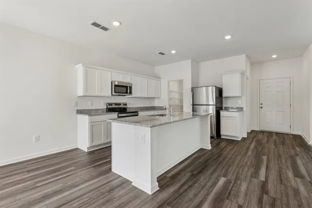 a kitchen with a refrigerator and a stove top oven