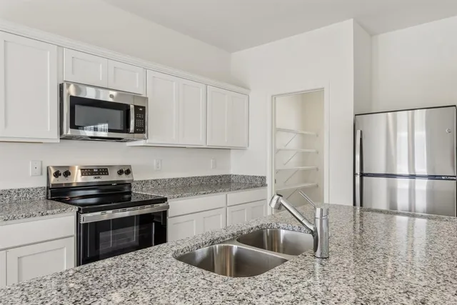 a kitchen with a sink stove and refrigerator