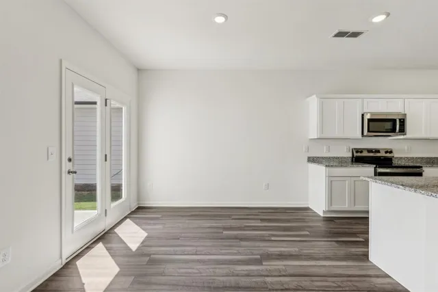 a view of a kitchen with wooden floor and a sink