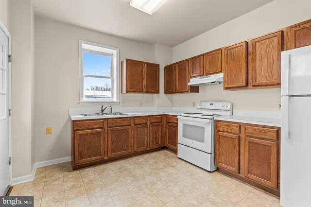 a kitchen with granite countertop a sink stainless steel appliances and cabinets