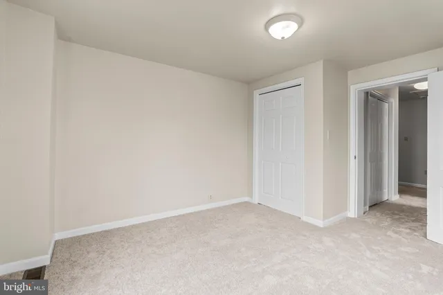 an empty room with closet and a bathroom