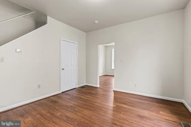 a view of empty room with wooden floor