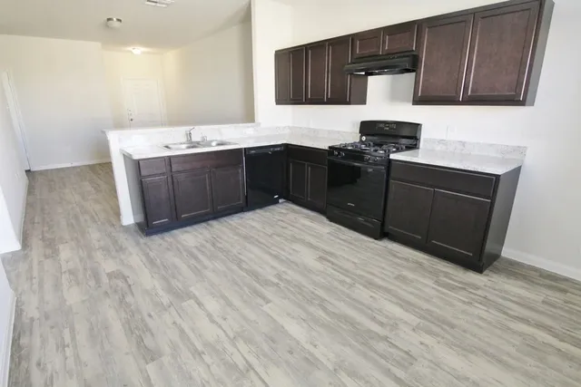a kitchen with stainless steel appliances granite countertop a sink stove and microwave