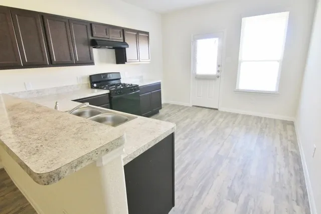 a kitchen with a sink dishwasher and wooden cabinets