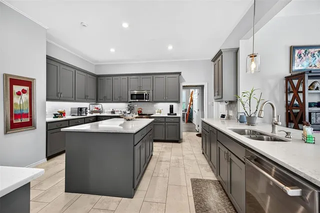 a kitchen with kitchen island a sink dishwasher stove and cabinets