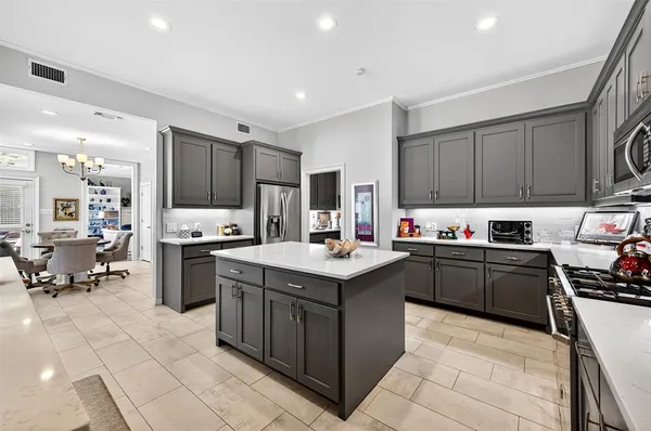 a kitchen with kitchen island granite countertop a sink counter top space appliances and cabinets
