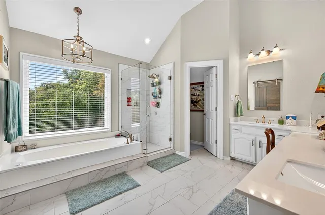 a spacious bathroom with a granite countertop tub sink and mirror