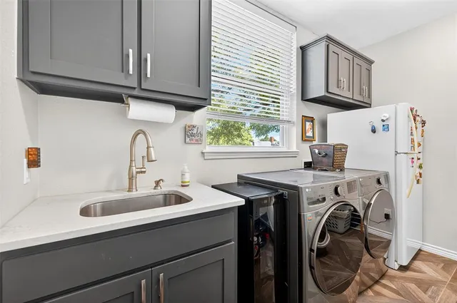 a utility room with sink dryer and washer