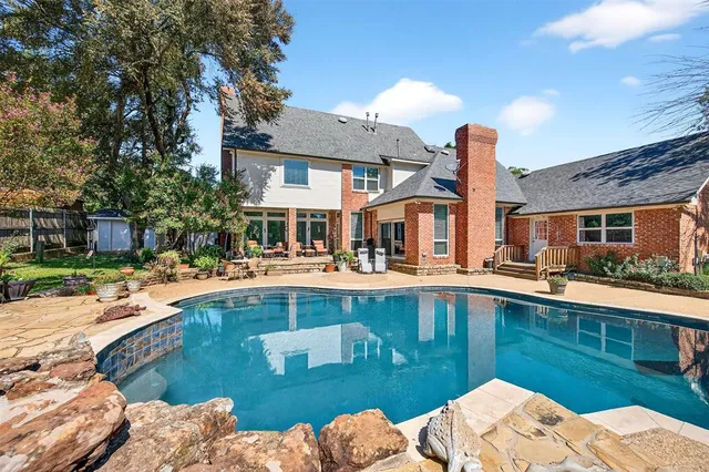 a view of a house with pool lawn chairs and a fire pit