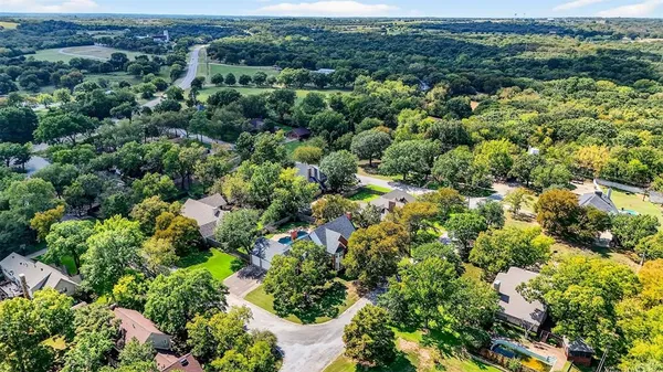an aerial view of residential house with outdoor space and trees all around