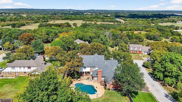an aerial view of residential houses with outdoor space and trees