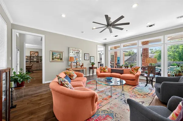 a living room with furniture ceiling fan and a large window