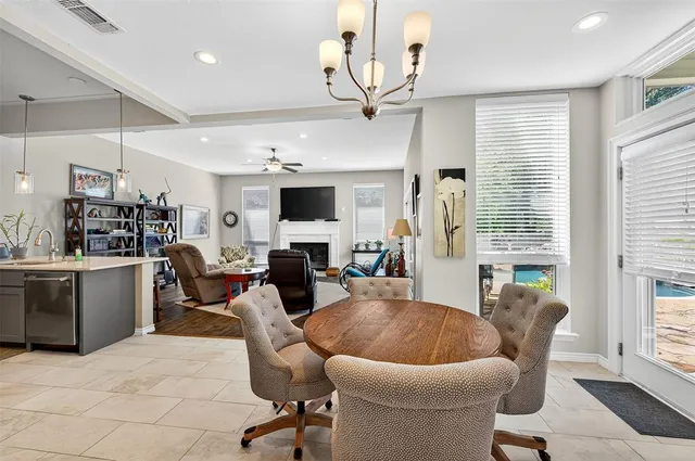 a living room with furniture kitchen view and a chandelier