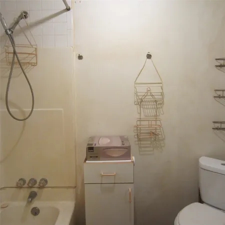 a bathroom with a granite countertop sink a toilet and shower