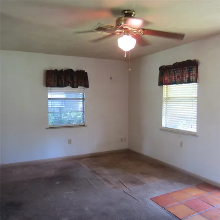 a view of a room with a ceiling fan and a window