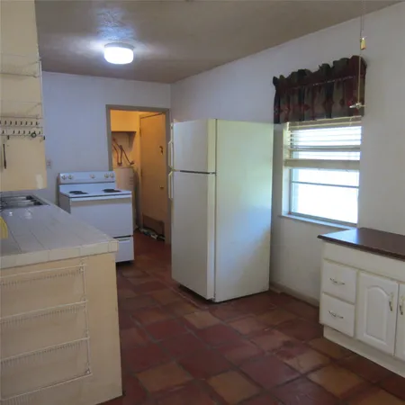 a kitchen with a refrigerator and cabinets