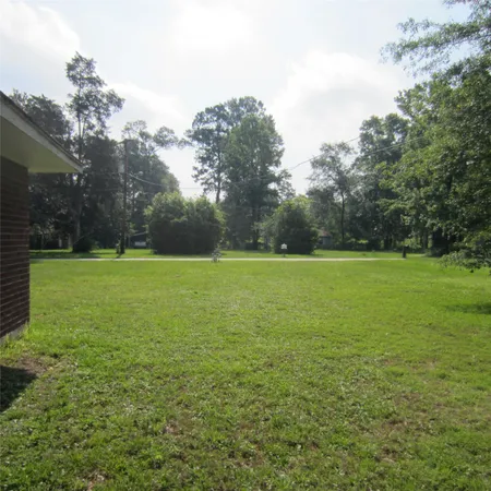 a view of a grassy field with trees in the background