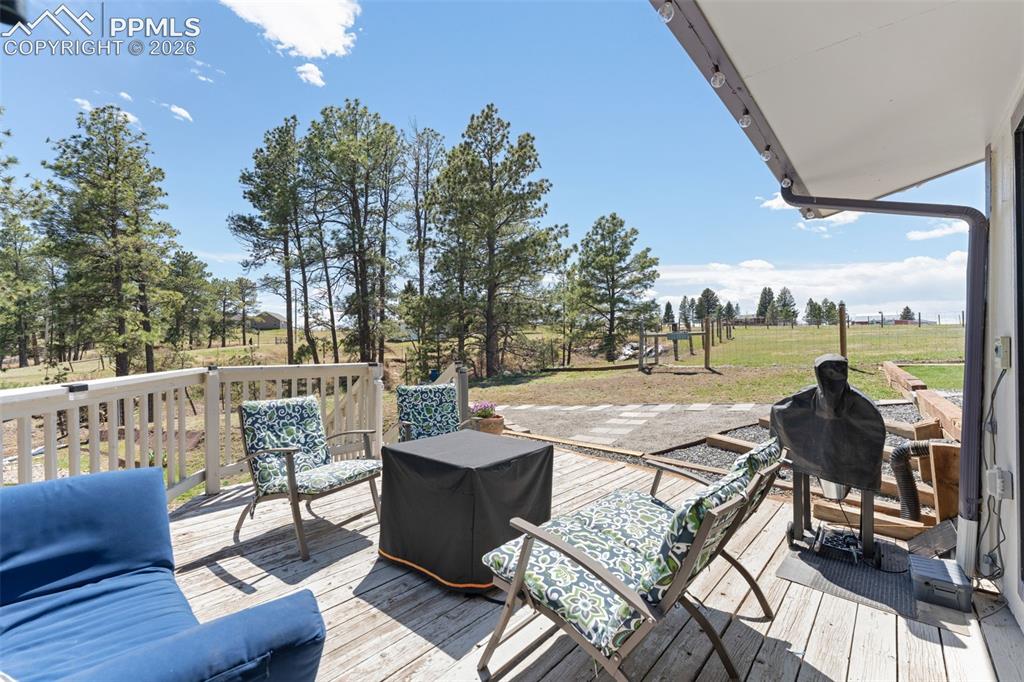 1851 Buttercup Road Elizabeth, CO 80107 - Photo 36 of 47 a view of a patio with dining table and chairs with wooden floor and fence